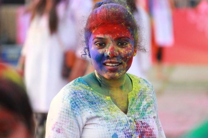 Fille recouverte de poudres de couleur pour Holi