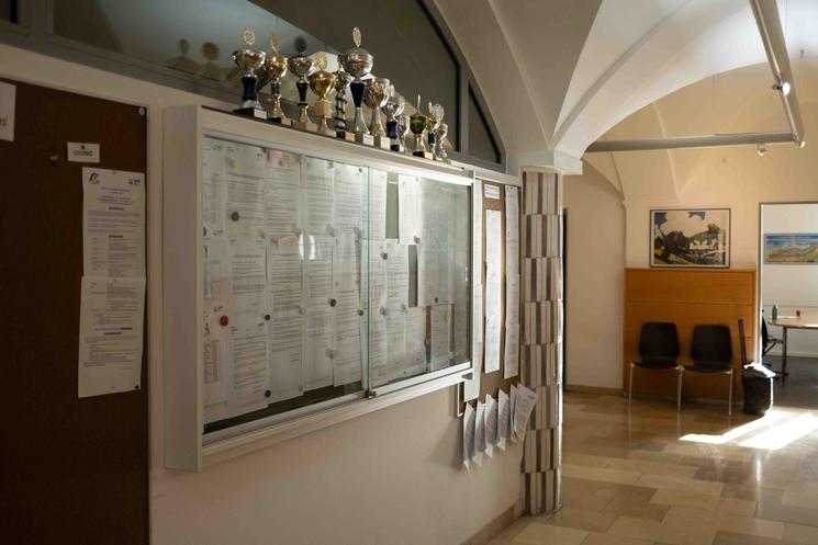 Le hall de l'administration du lycée Jean Renoir avec une vitrine et de multiples trophées.