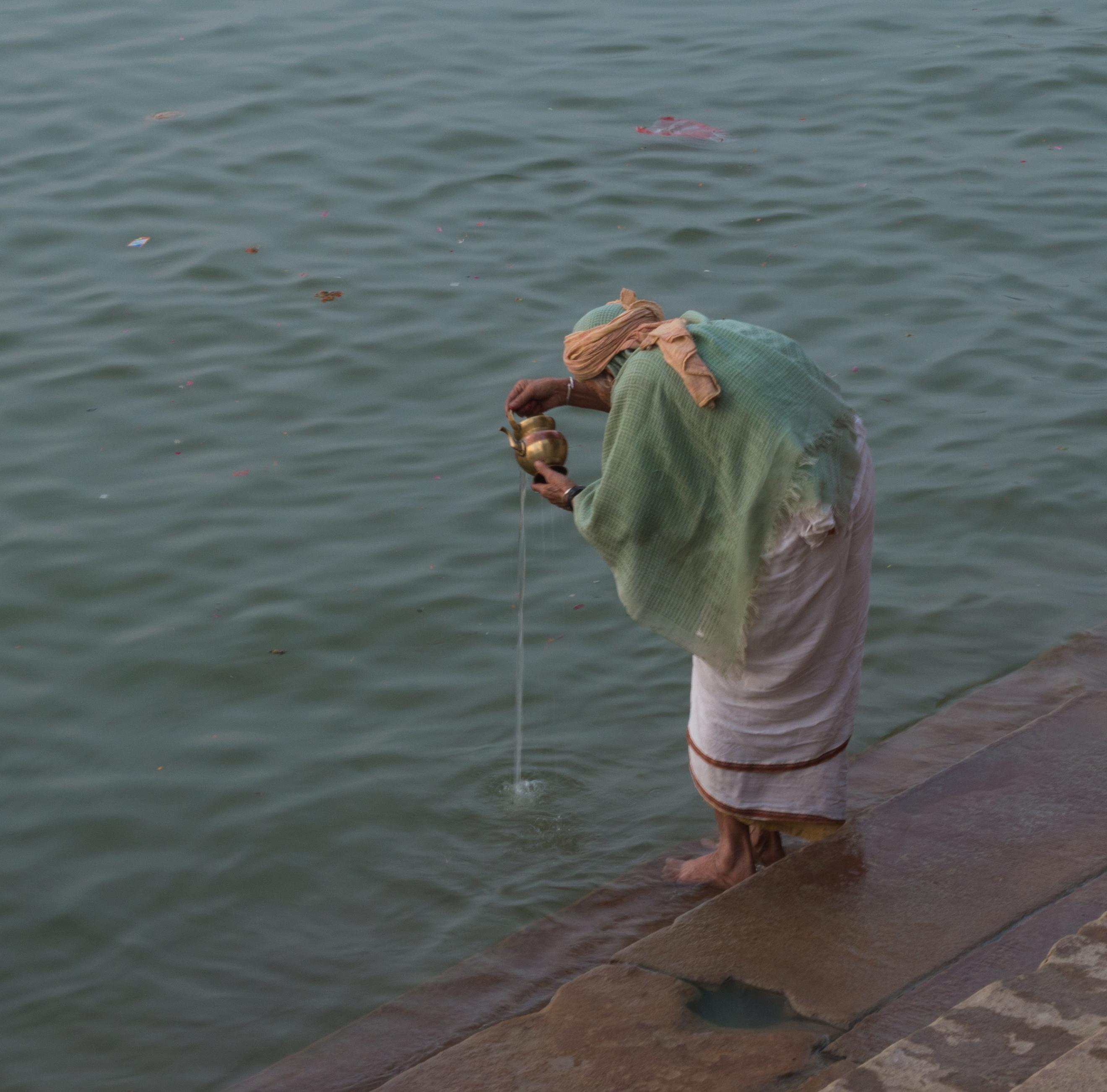 un homme effectuant un rituel dans le gange en inde