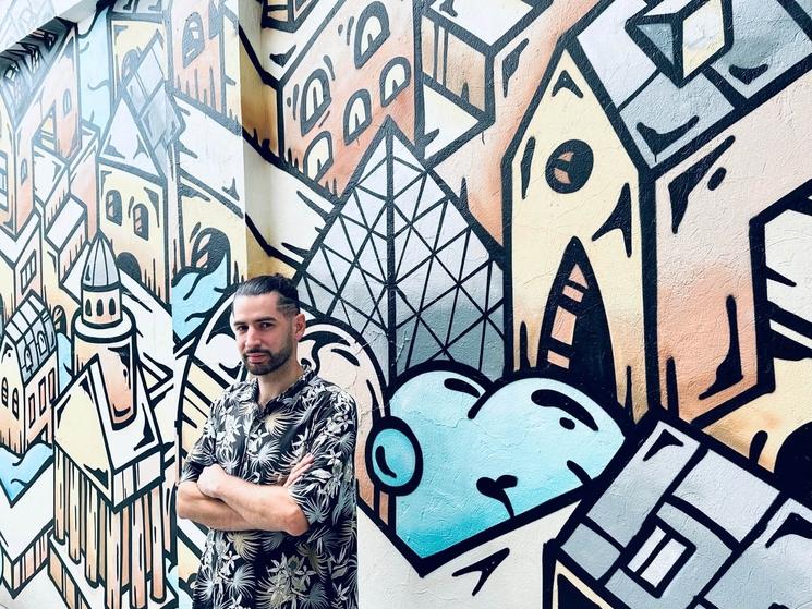 Portrait artiste français Takir Vortex devant son mural à l'Alliance Française de Bogota