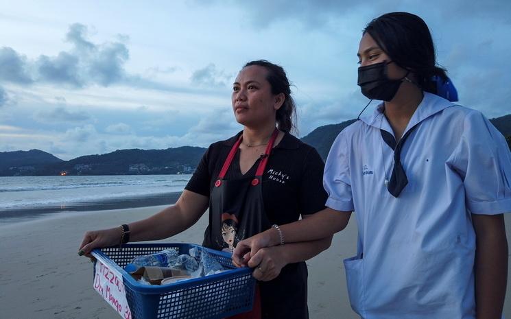 Une retauratrice de Phuket vend de la nourriture sur la plage avec sa fille