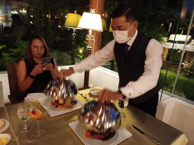 Un serveur au restaurant Le Crystal leve les cloches couvre-plat