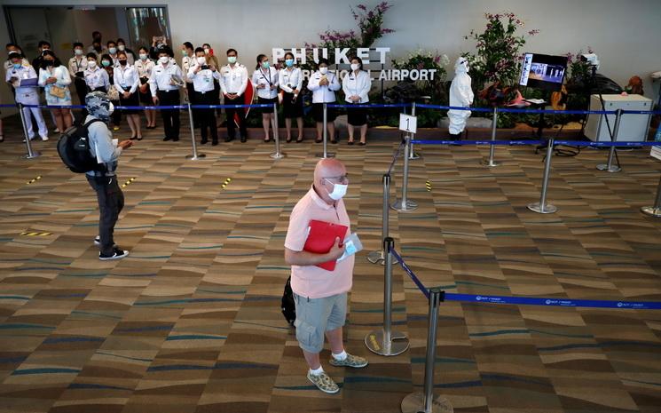 Arrivee d'un touriste a l'aeroport de Phuket avec le comite d'accueil