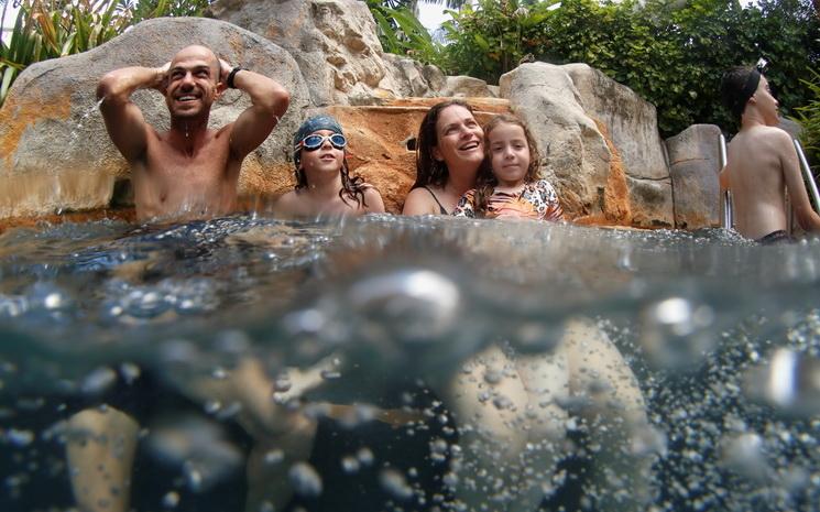 Une famille de touristes profitent de la piscine dans un hotel de Phuket