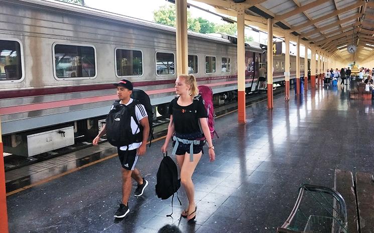 Un couple de touristes europeens marchent sur le qua de la gare ferroviaire de Chiang Mai