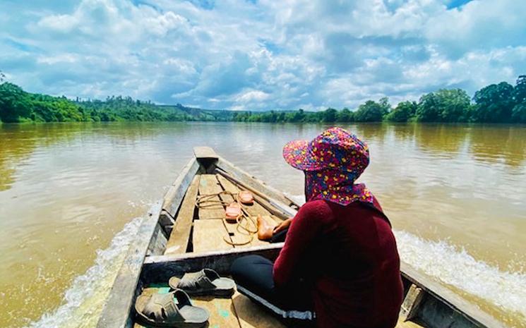 Vue d'une bateliere khmere menant sa barque vers un village Jarai dans le Ratanakiri au Cambodge