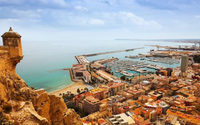 Une vue en hauteur du chateau et du port d'Alicant avec ses bateaux