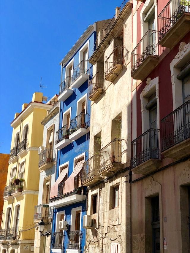 des facades des maisons bleues, blanches et rouges a alicante