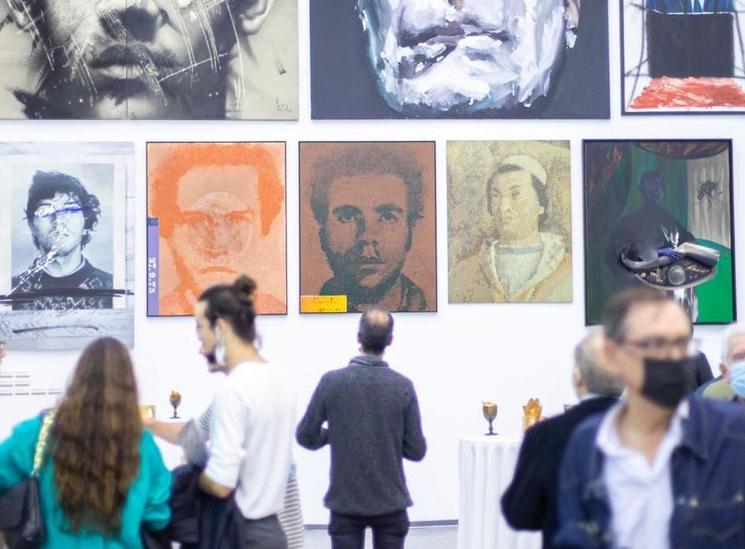 Un homme en train de regarder des tableaux lors d'une exposition