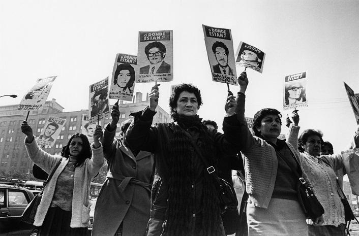 des femmes brandissent des portraits de leurs proches disparus