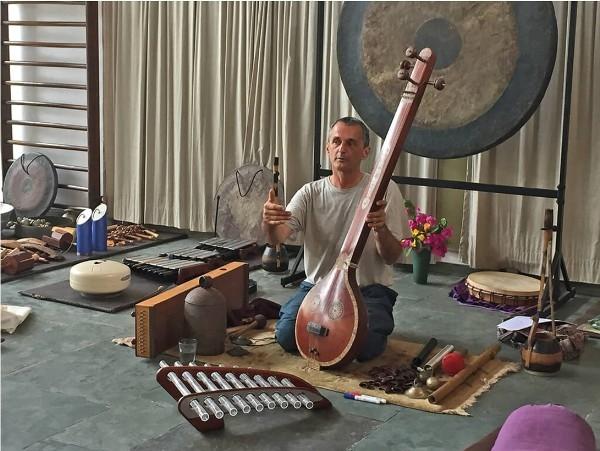 Aurelio fondateur de Svaram au milieu d'anciens instruments de musique