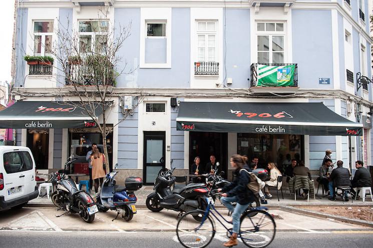 un immeuble bleu avec une terrasse et une personne en train de faire du vélo