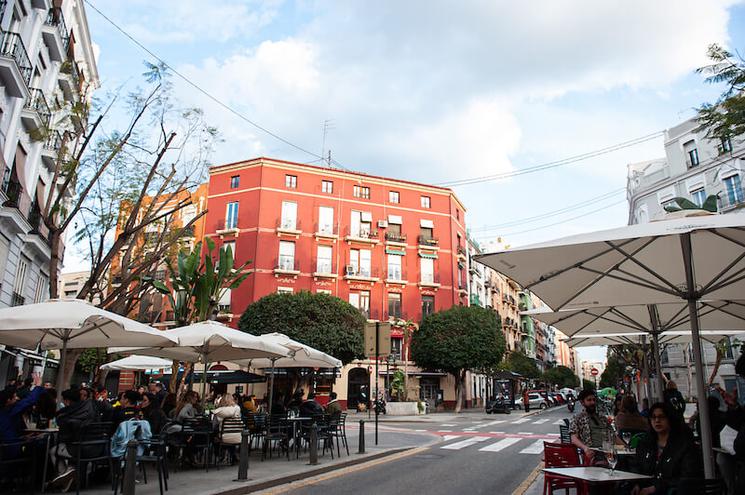 des terrasses avec des parasols et un immeuble organge