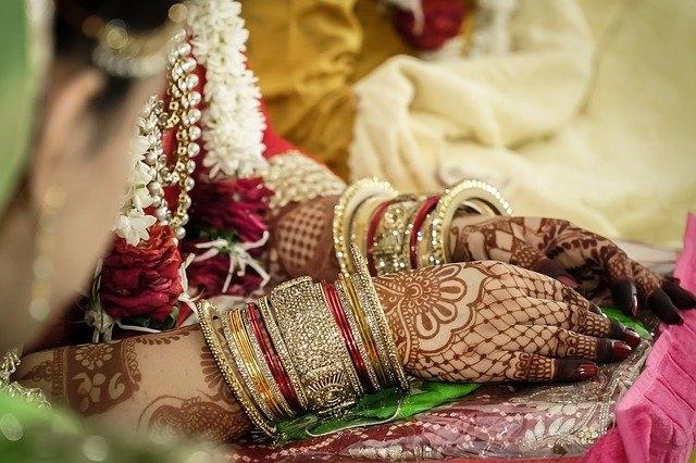 bras d'une mariée chargé de bracelets et de mehendi