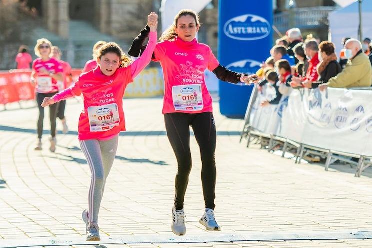 une femme qui soulève le bras d'une fille en train de courir