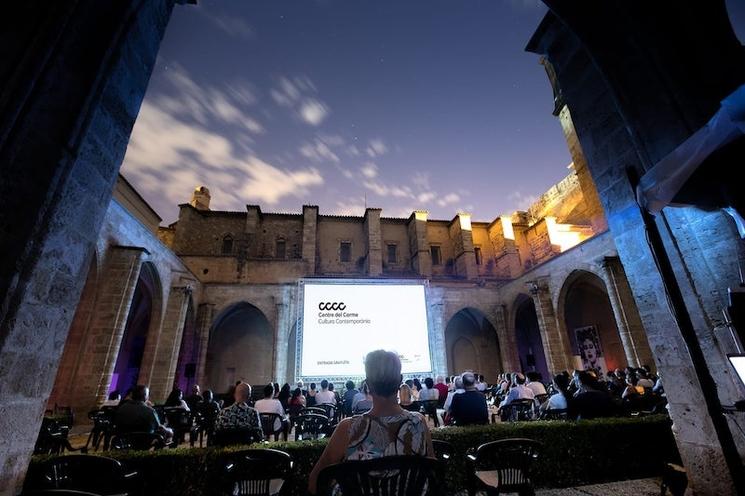 Une projection sur un écran géant dans un cloître le soir