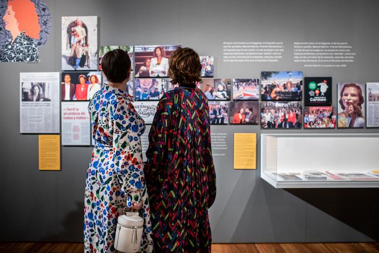 Deux femmes avec des robes de couleur vive en train de lire des affiches