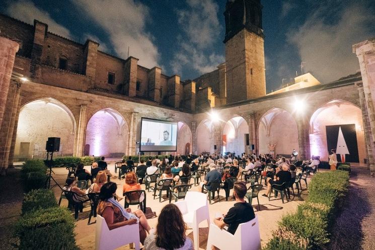 un concert de musique et des personnes assises dans un cloitre