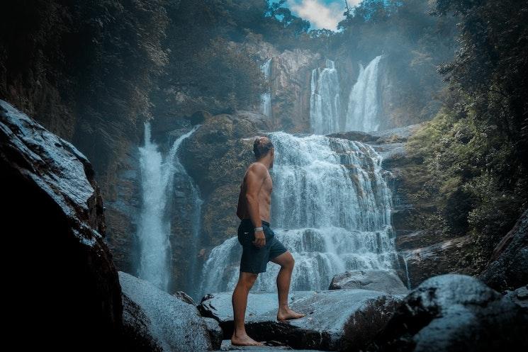 Un homme devant une cascade au Costa Rica