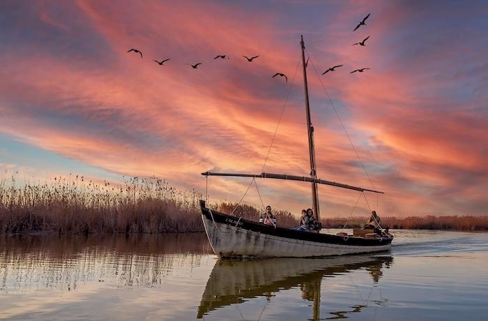 une barque de pecheur sur l abufera au coucher de soleil