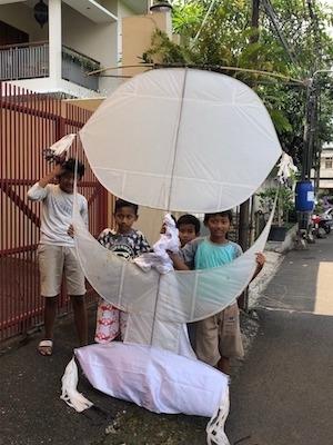 des enfants dans la rue de jakarta avec leur cerf volant