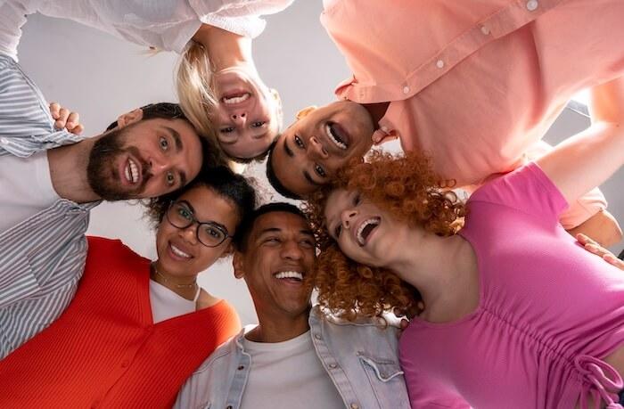 visages souriants de personnes vus d'en bas