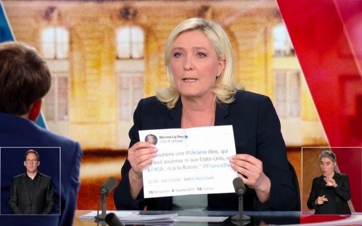 Marine Le pen montre un papier à Macron pendant le débat