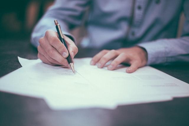 un homme en train de signer un document