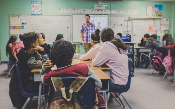 Des élèves dans une salle de classe devant un professeur