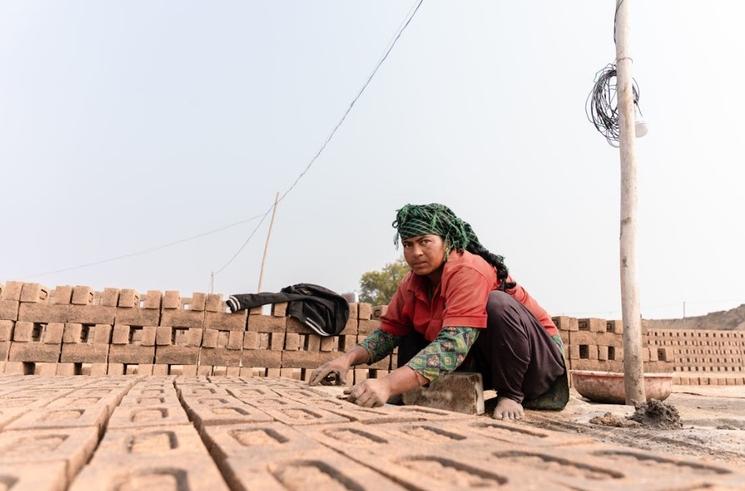 Femme fabriquant des briques en Inde