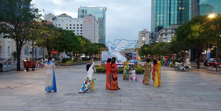 Des femmes vietnamiennes portent la tenue traditionnelle Ao Dai sur l'avenue Nguyen Hue a Ho Chi Minh Ville