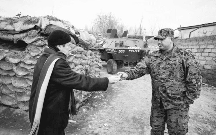 L'ambassadeur de France en Géorgie, Eric Fournier, offre une cigarette à un soldat géorgien pour établir le contact