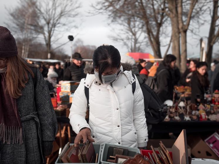 Une personne portant un masque dans un marché aux puces