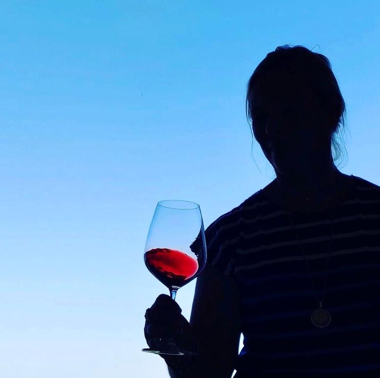 Une femme en train de déguster du vin rouge 