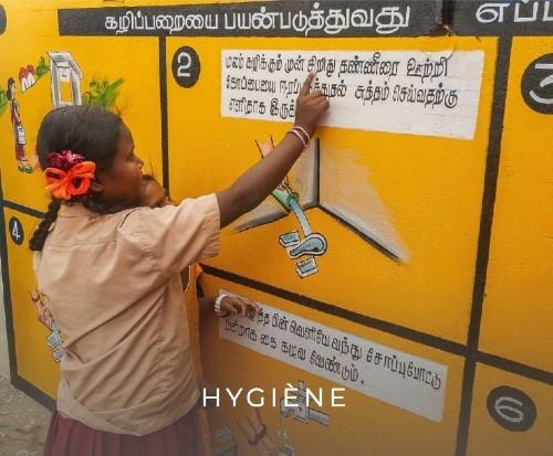 Petite fille du Tamil Nadu lisant une affiche sur l'hygiène