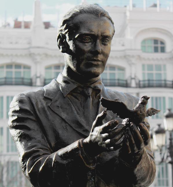 Photo d'une statue qui représente un homme avec un pigeon 