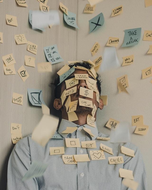 Un homme recouvert de post-its avec le message "take a break"