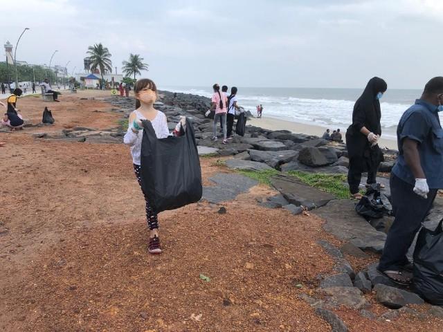 une eleve du lycee francais de Pondichery avec un sac poubelle plein