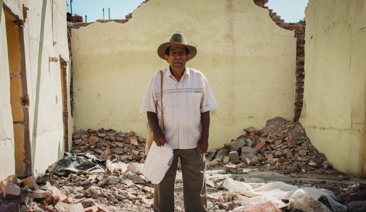 Un homme au milieu d'une maison détruite