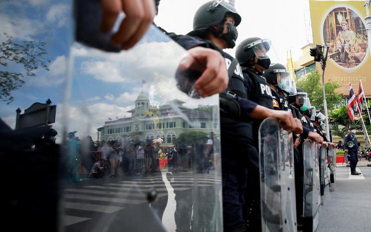 Un barrage de policier en tenue anti-emeute bloque les manifestants a Bangkok