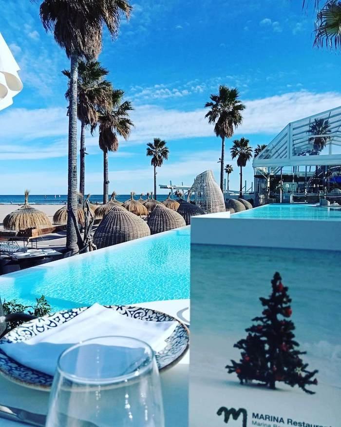 Le marina beach club avec une piscine et des palmiers au bord de la mer à Valencia