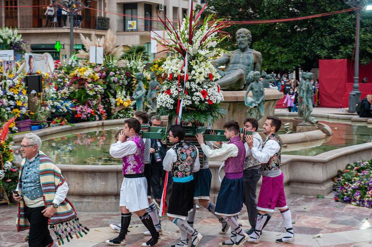 des hommes en train de porter une composition florale