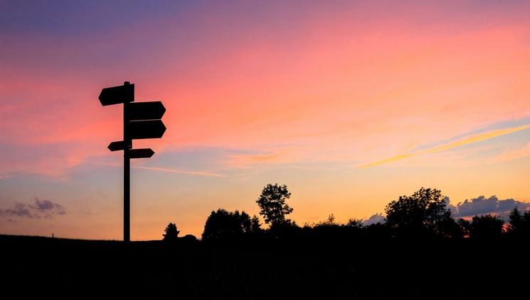 comprendre vers ou on va grâce à un panneau d'orientation au coucher du soleil 