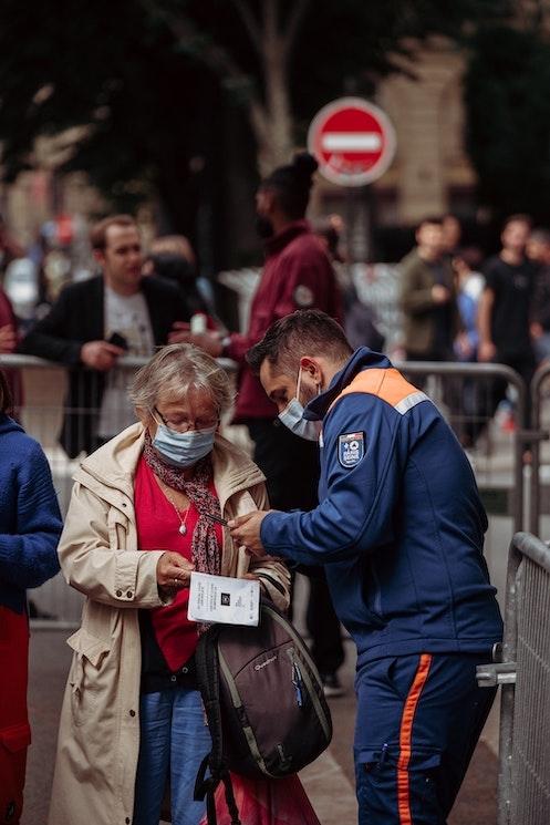 Un employé vérifiant le passe sanitaire d'une expatriée