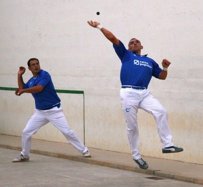 Deux sportifs en train de jouer à la pelota valenciana sur un trinquet