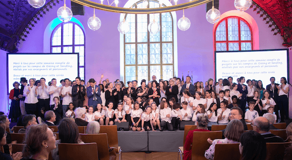 Photo de groupe des élèves sur scène lors de la cérémonie de célébrations des 70 ans du lycée Jean Renoir à Munich.