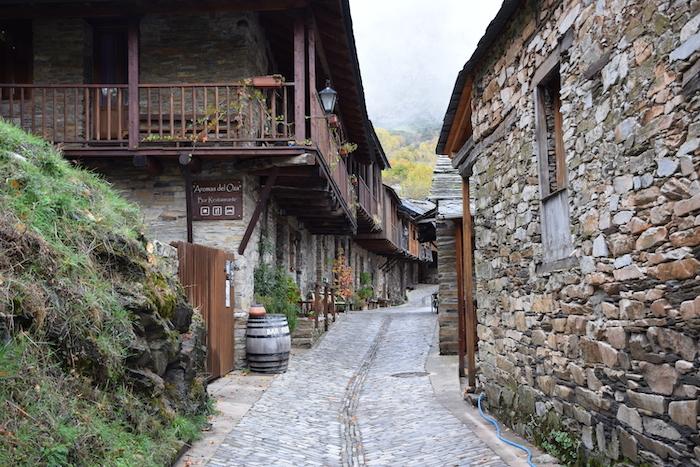 Une ruelle avec des maisons aux murs en ardoise et pierres