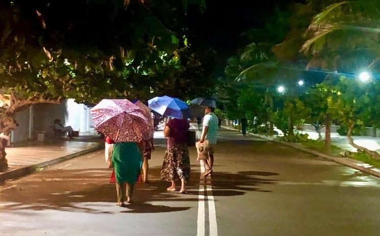 Des promeneurs avec parapluies sur le bord de mer de Pondichéry