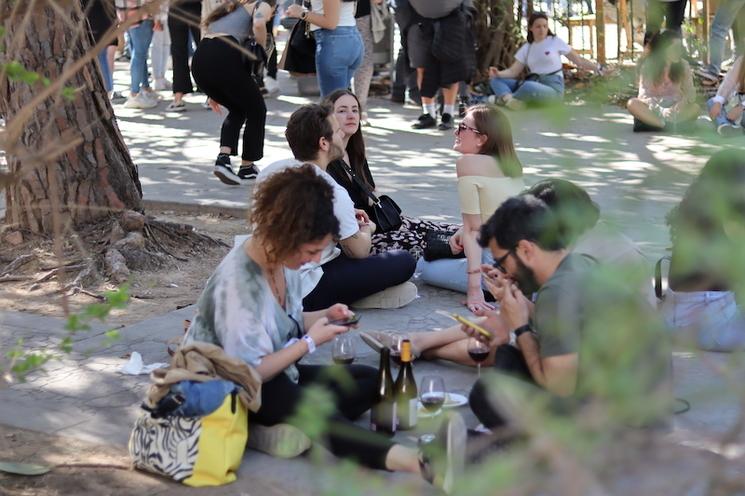 des personnes assises par terre en train de boire et manger dans le festival mostra proava