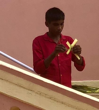 Un Indien créant une croix avec une feuille de palme